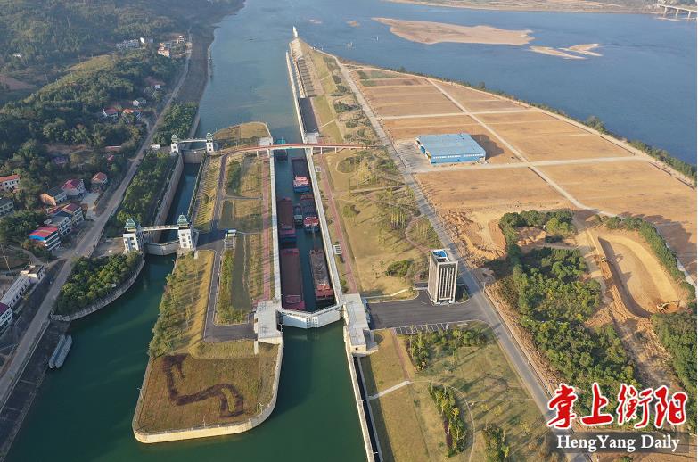 一队大型运输船舶正缓缓通过大源渡航电枢纽船闸